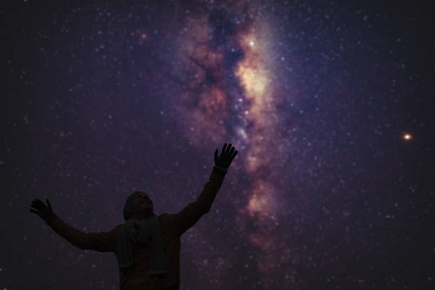 istock Man enjoying starry night with arms wide open. 1195181954