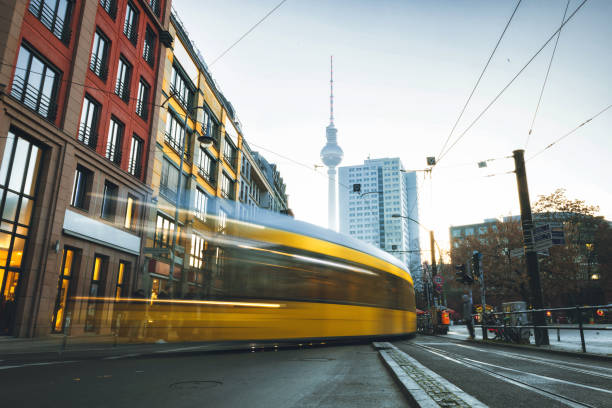 istock yellow train passing street in central Berlin at sunrise 1195183041