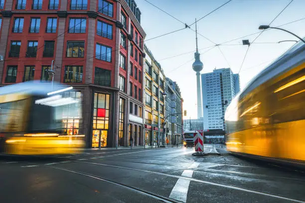 long exposure of yellow street car in Berlin Mitte at sunrise hour in front of TV-Tower
