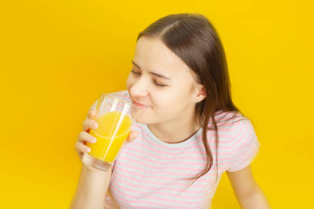 istock Girl drinks orange juice 1195187753