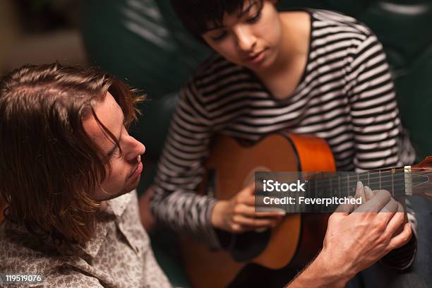 Jovem Músico Ensina A Aluna A Tocar Guitarra Para - Fotografias de stock e mais imagens de Adulto - Adulto, Aprender, Artista