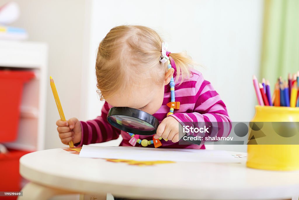 Toddler girl looking through magnifier  Magnifying Glass Stock Photo