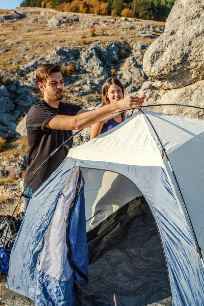 istock Young Couple Preparing Tent Camp 1195196765