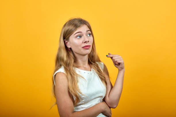 istock Disappointe blonde young woman keeping hand on stomach, looking aside 1195200700