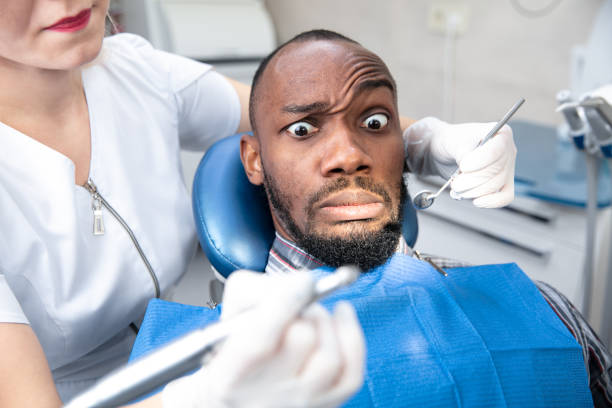 istock Young african-american man visiting dentist's office, looks scared 1195201939