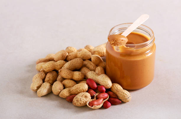istock Peanut butter in a jar and peanuts in shells near 1195202669