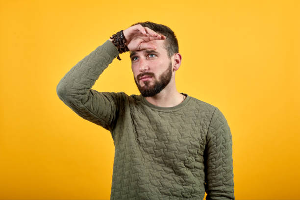 istock Handsome serious man keeping hands on forehead, wearing casual green clothes 1195211276