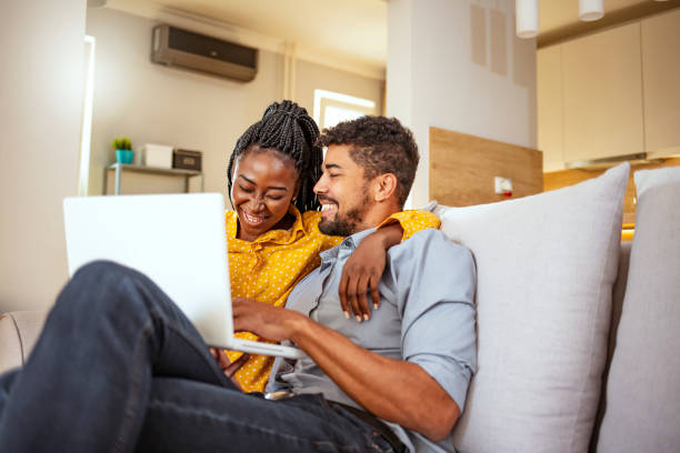 istock Young black couple using laptop at home 1195218195