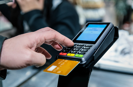 Hombre pagando compras con entrada de PIN de tarjeta de crédito en el supermercado photo