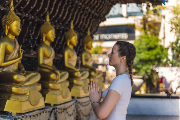 istock young happy tourist praying in a buddhist temple 1195222320