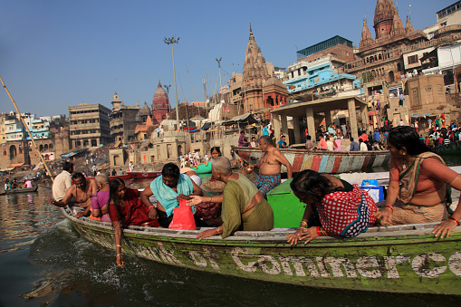 Varanasi, India- March 07,2016: Unidentified people in a boat travel across the holy river Ganges in Varanasi, Uttar Pradesh, India.Varanasi is one of the ancient cities in world.