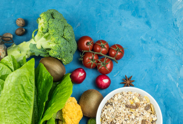 istock Cuisine - fresh colorful organic vegetables captured from above (top view, flat lounger). Blue background. Layout with free text (copy) space. vegan food. healthy food 1195226836
