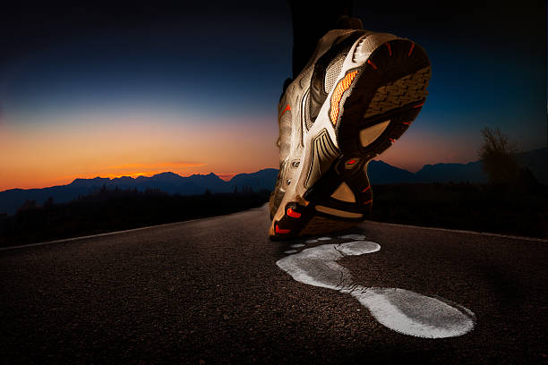 Sneaker and white footprint on asphalt at dawn stock photo