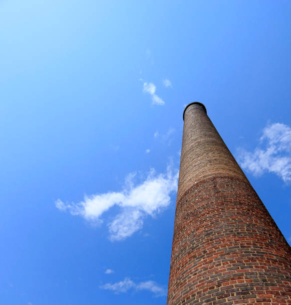 istock Old brick chimney and clear blue sky from low angle 1195228291