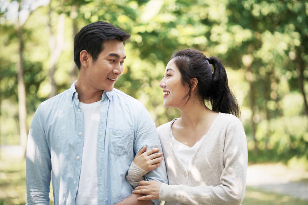istock young asian couple relaxing outdoors in park 1195228335
