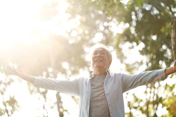 istock asian old man enjoying fresh air outdoors in park 1195228402