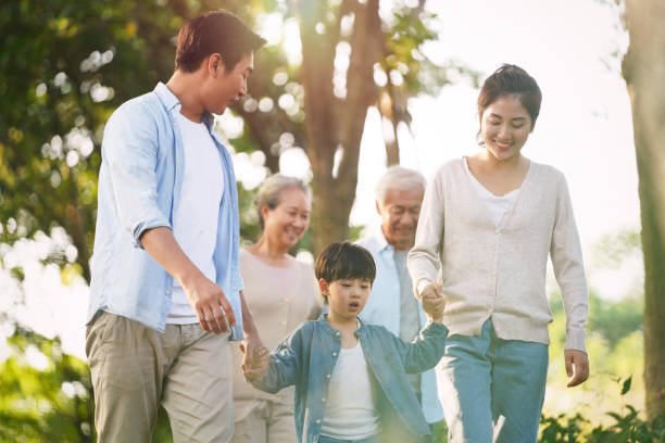 multi generation asian family relaxing outdoors in park three generation happy asian family walking outdoors in park china chinese ethnicity smiling grandparent stock pictures, royalty-free photos & images