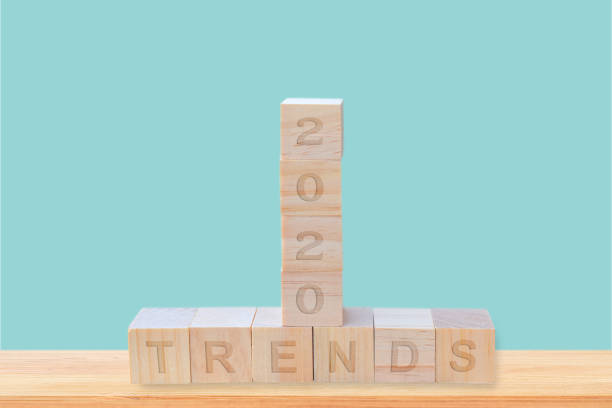 istock 2020 trends written on wooden block cube on blue background. design concept 1195230976