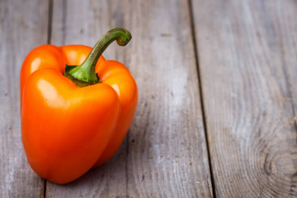 istock fresh orange pepper  on a rustic wooden background 1195231977