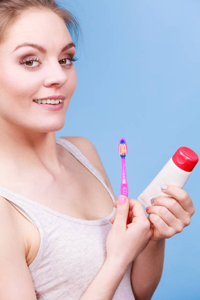 istock Woman holds toothbrush and paste for teeth cleaning 1195231998