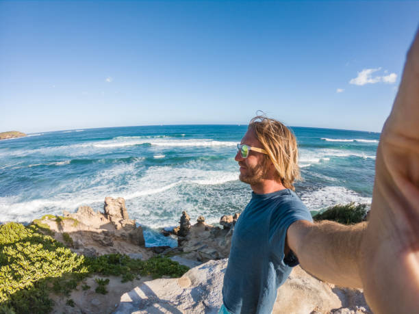 istock Man in Hawaii taking selfie by the coastline 1195232149