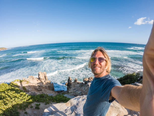 istock Man in Hawaii taking selfie by the coastline 1195232354