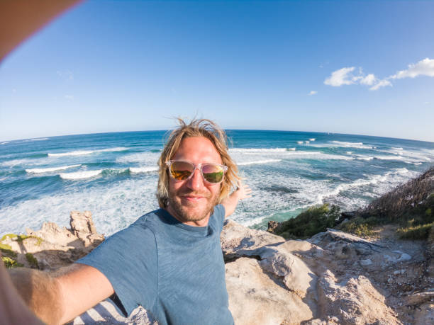 istock Man in Hawaii taking selfie by the coastline 1195232966
