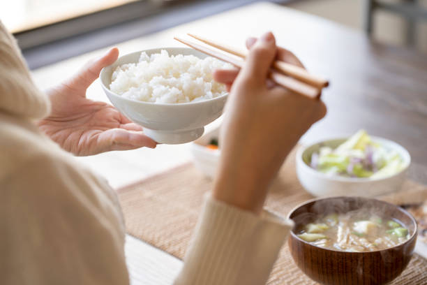 Hand of young woman eating breakfast Hand of young woman eating breakfast washoku stock pictures, royalty-free photos & images