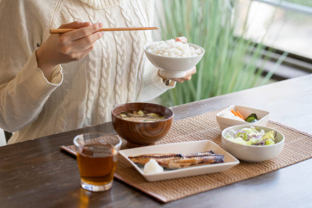 hand der jungen frau essen frühstück - japanische küche stock-fotos und bilder