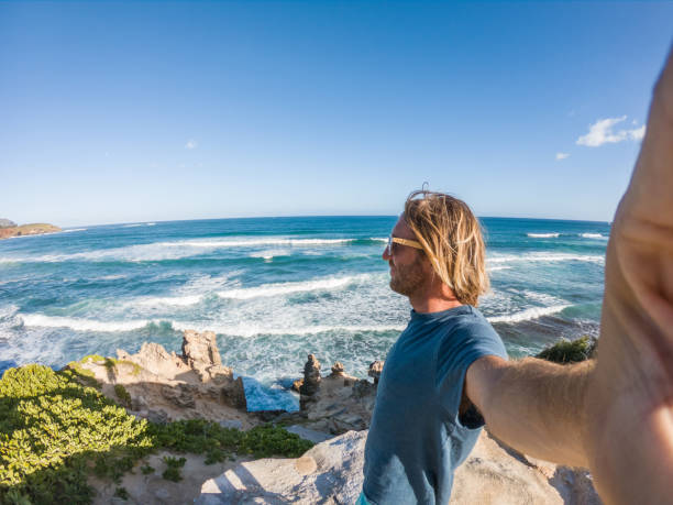 istock Man in Hawaii taking selfie by the coastline 1195233072