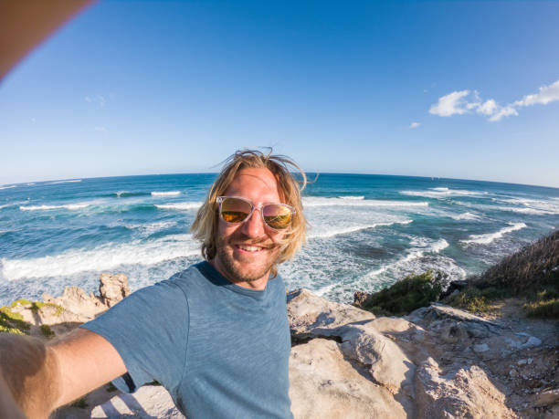 istock Man in Hawaii taking selfie by the coastline 1195233156
