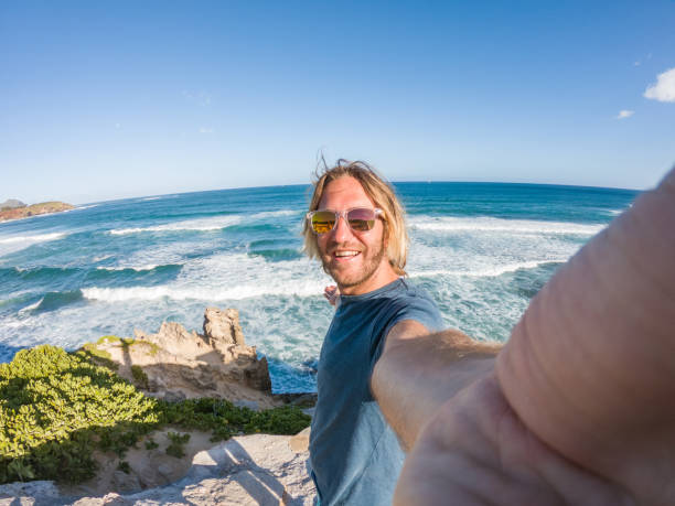istock Man in Hawaii taking selfie by the coastline 1195233157