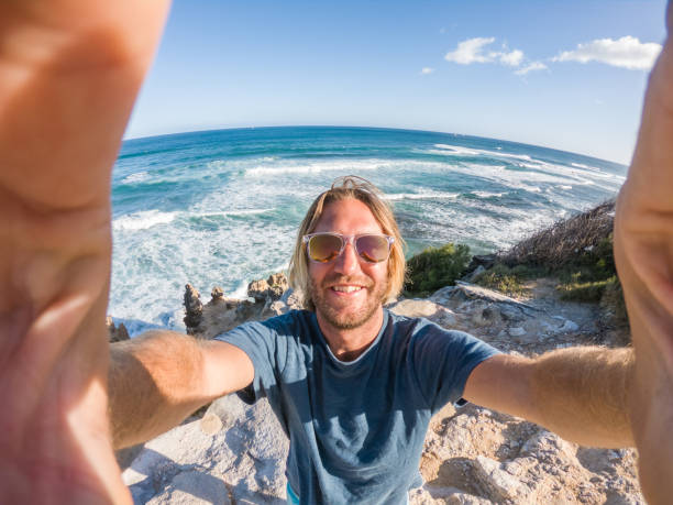 istock Man in Hawaii taking selfie by the coastline 1195233375
