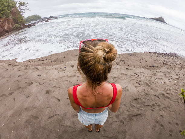 istock Young woman contemplating beach, wide angle 1195238138