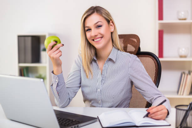 istock Businesswoman eating apple while working 1195239494