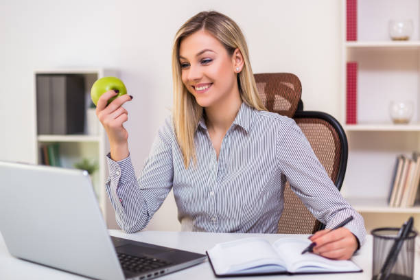 istock Businesswoman eating apple while working 1195239764