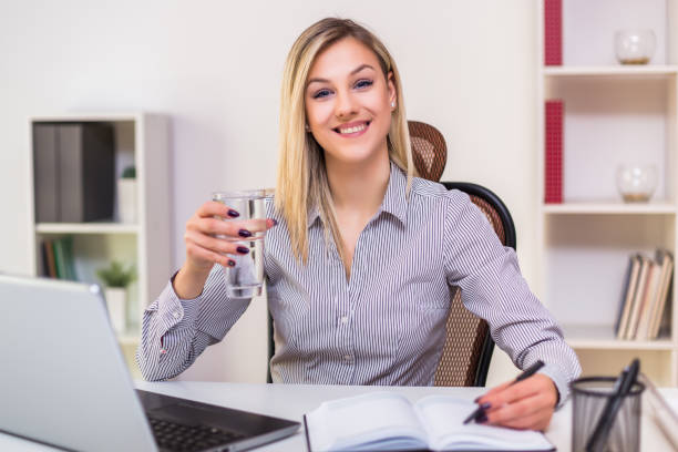 istock Businesswoman drinking water while working 1195239783