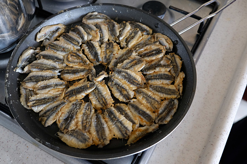 anchovy fish cooked on a stove, cooking anchovy in a pan, anchovy in a Turkish style pan,