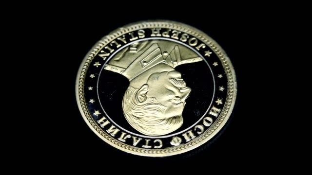 Russian souvenir coin Joseph Stalin rotates on a black background. Macro. Closeup