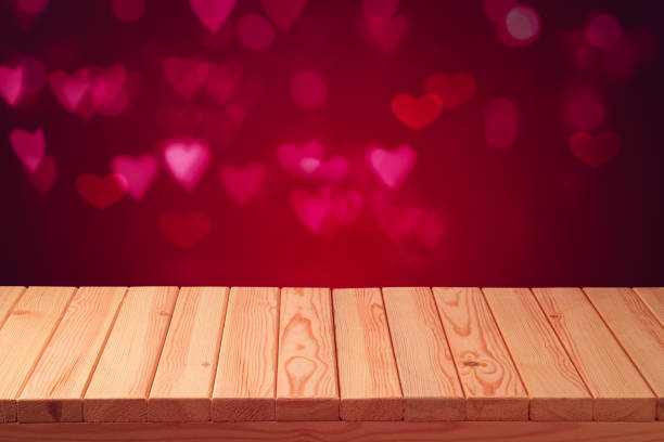 Empty wooden table over bokeh heart shape background. Valentines day concept celebration.