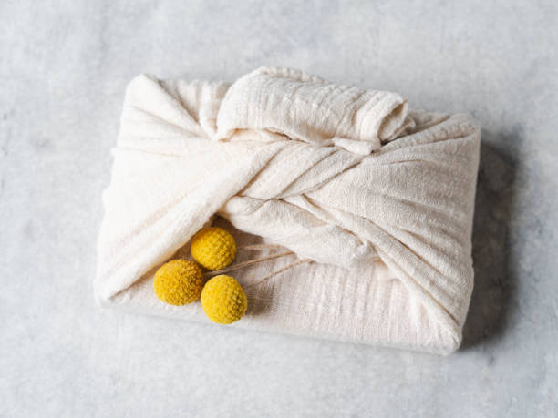 istock Eco-friendly fabric reusable gift packaging with dry yellow flowers. Romantic reusable sustainable gift wrapping alternative. Zero waste concept. Top view 1195246652