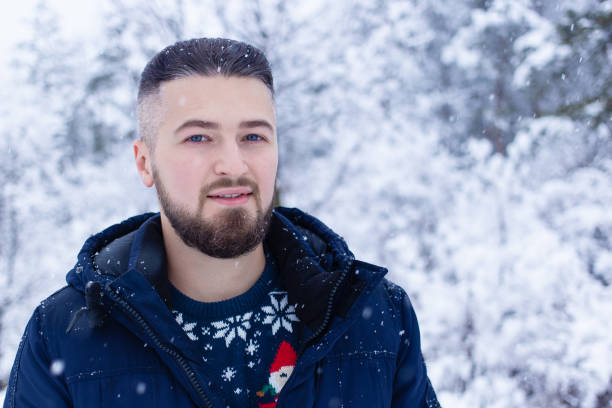 istock Young handsome man in snowy forest 1195247968