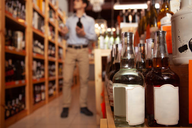 istock Handsome man shopping for alcohol at liquor store 1195248874