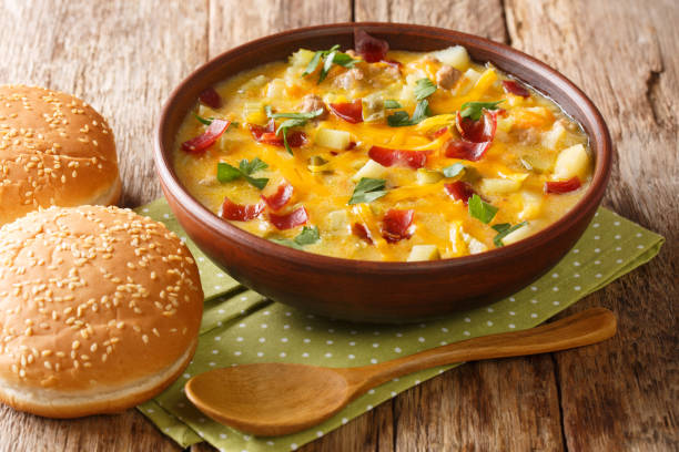 Serving of cheeseburger soup with vegetables, ground beef, bacon and cheese close-up in a bowl. horizontal Serving of cheeseburger soup with vegetables, ground beef, bacon and cheese close-up in a bowl on the table. horizontal cheeseburger stock pictures, royalty-free photos & images
