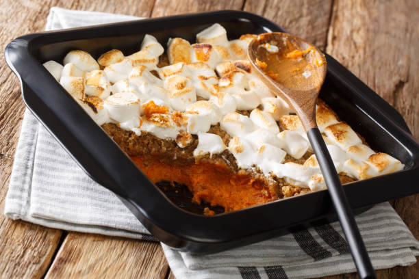 istock Sweet potato casserole with pecans topped with marshmallows close-up in a baking dish. horizontal 1195250108