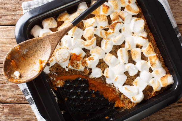 istock Sweet potato casserole with pecans topped with marshmallows close-up in a baking dish. Horizontal top view 1195250232