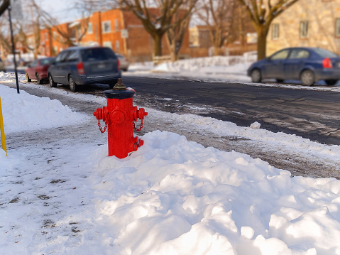 Red fire hydrant on the sidewalk of a snowy street. prevention concept, safety,