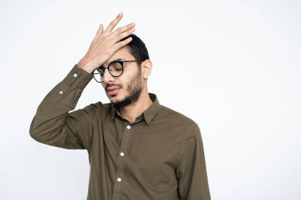 istock Embarrassed businessman in eyeglasses keeping his hand on forehead in isolation 1195255766