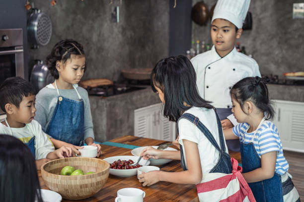 istock Childhood students and friends learning how to cooking in kitchen at school class 1195256679