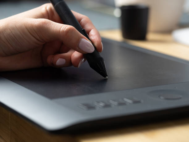 istock graphic designer at work. The designer draws a graphic pen on the tablet 1195256904